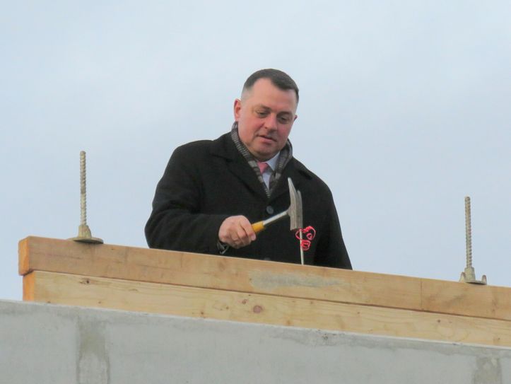 Landrat Udo Witschas beim Einschlagen des letzen Nagels während des Richtfestes. Foto: Matthias Stark