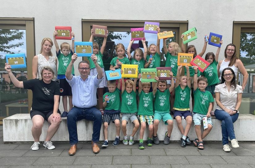 Kinder der Kita "Piffikus" halten die Lernbausteine des ABC-Clubs hoch.