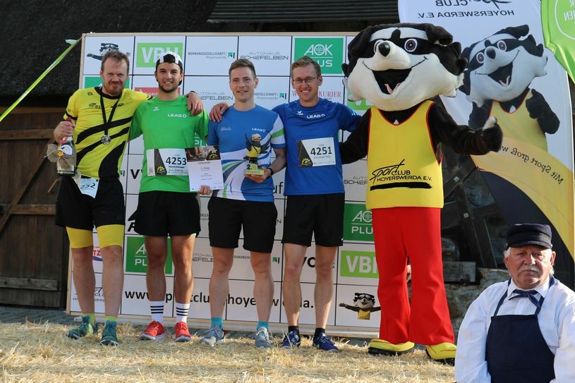 Der SC-Bär gratuliert den glücklichen Gewinnern des 2. SC-Krabat-Firmenlaufes, dem Team der LEAG. Neben Urkunden gab es auch einen handgetöpferten Rabenpokal für die Sieger. Foto: Werner Müller