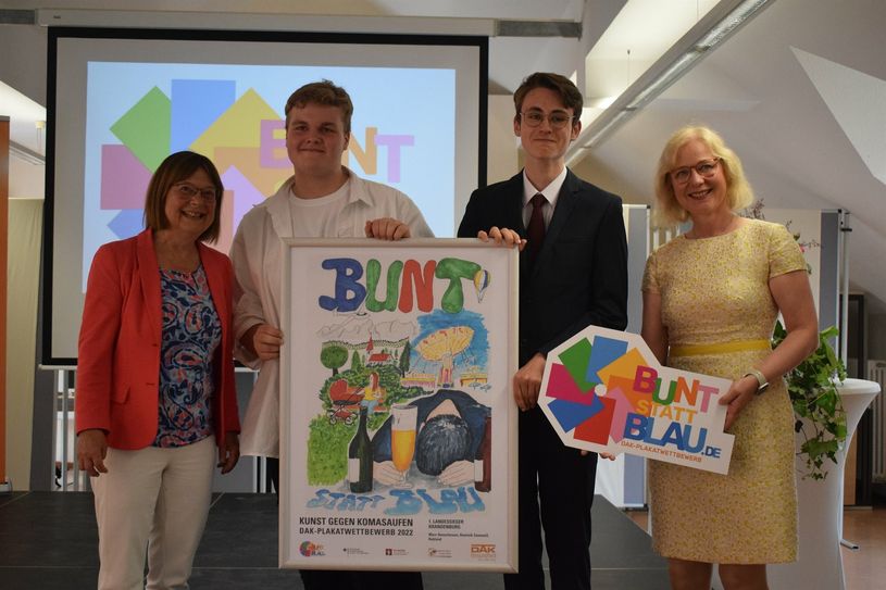 Gesundheitsministerin Ursula Nonnemacher (l.) und Anke Grubitz, Leiterin der Landesvertretung der DAK-Gesundheit (r.) mit den Gewinnern des Plakatwettbewebs »bunt statt blau« Dominik Zaumseil und Marc Hanschmann.