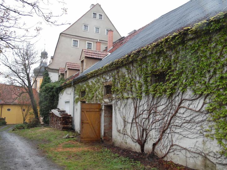 Der Bullenstall von außen mit der Kirche Zuschendorf im Hintergrund.