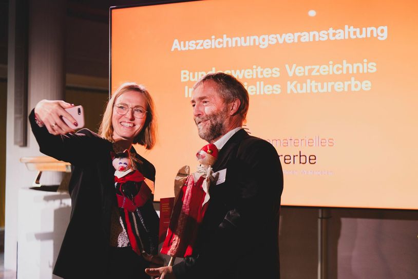 Susanne Wegener und Ralf Uschner holten gemeinsam mit Kasper und Teufel die Urkunde in Düsseldorf ab und sorgten auch gleich noch für Öffentlichkeitsarbeit. Foto: Deutsche UNESCO-Kommission/Bettina Engel-Albustin