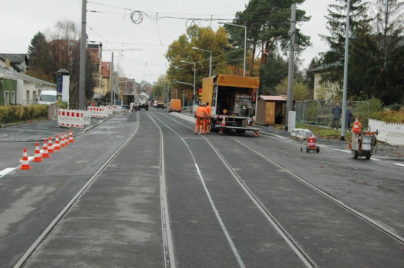 Bauarbeiter erledigen letzte Restaufgaben, bevor hier ab Sonntag die Straßenbahnen wieder über die Gleise donnern. Foto: Pohl