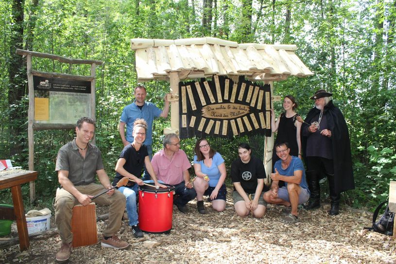 Mühlenchef Tobias Zschieschick (rechts hockend), die Initiatoren und Mitarbeiter freuen sich, dass der Erlebnispfad nun auch dieses Instrument zu bieten hat. Doreen Zschiesche von der Projektleitung der »Offenen Jugendwerkstatt« hatte für ein musikalisches Zusammenspiel ihre Trommel mitgebracht. Foto: sr