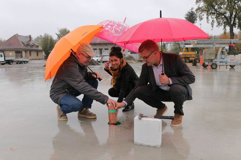 Die Zeitkapsel versenkten der Bürgermeister Karsten Schreiber (r.), die künftige Leiterin der Einrichtung, Eileen Leopold (Mitte), und der fraktionslose Vorsitzende der Gemeindevertretersitzung Hans-Georg Zubiks (l.). Foto: Mathias Klinkmüller