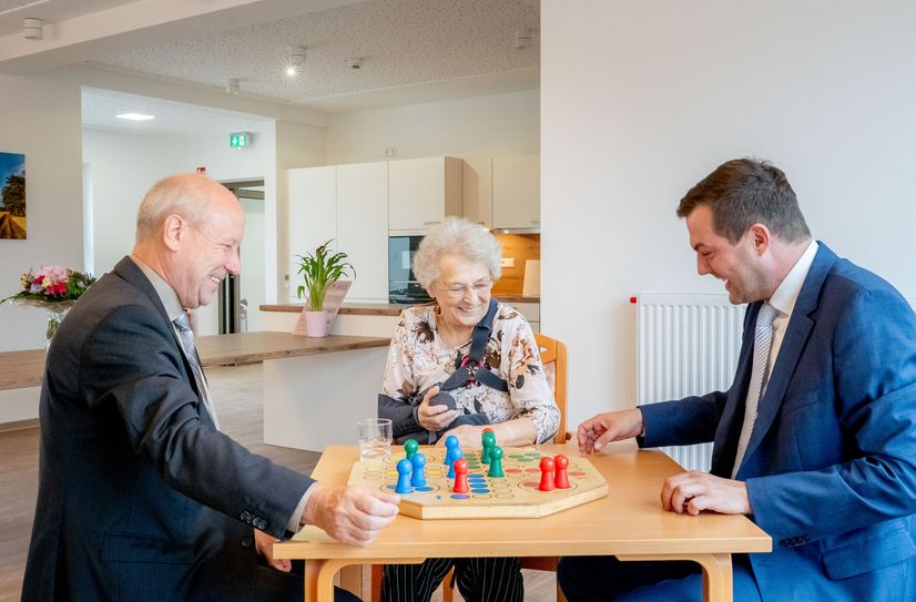 Bürgermeister Fred Mahro (l.) und Sozialwerke-Geschäftsführer Dr. Martin Reiher spielten mit der ersten Bewohnerin, Frau Engelmann, eine Runde »Mensch-ärgere-dich-nicht«.