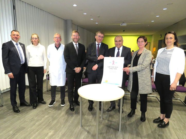 Landrat Udo Witschas (l.) mit dem medizinischen Leitungsteam des neuen Brustzentrums in Bautzen und der Gründungsurkunde.