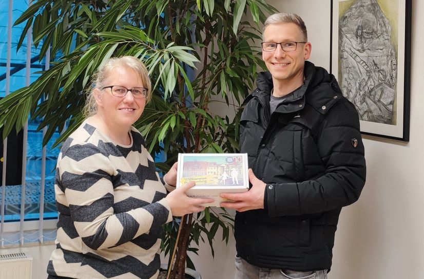 Die Projektkoordinatorin der Rückkehr- und Zuzugsinitiative, Anja Guhlan, überreicht die 100. Willkommensbox an den Neu-Spremberger Andreas Balke.