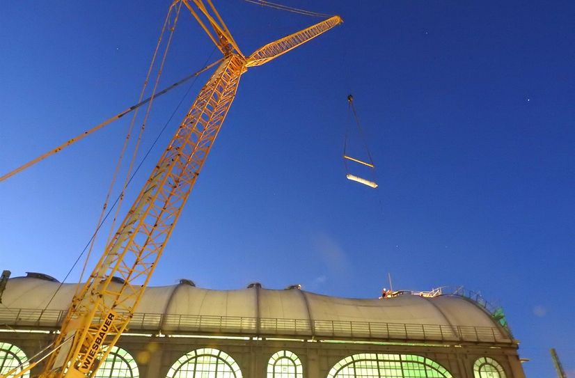 Da schwebt sie im nächtlichen Himmel über dem Dach des Dresdener Hauptbahnhofes: Die erste Rolle der neuen Glasfasermembran.