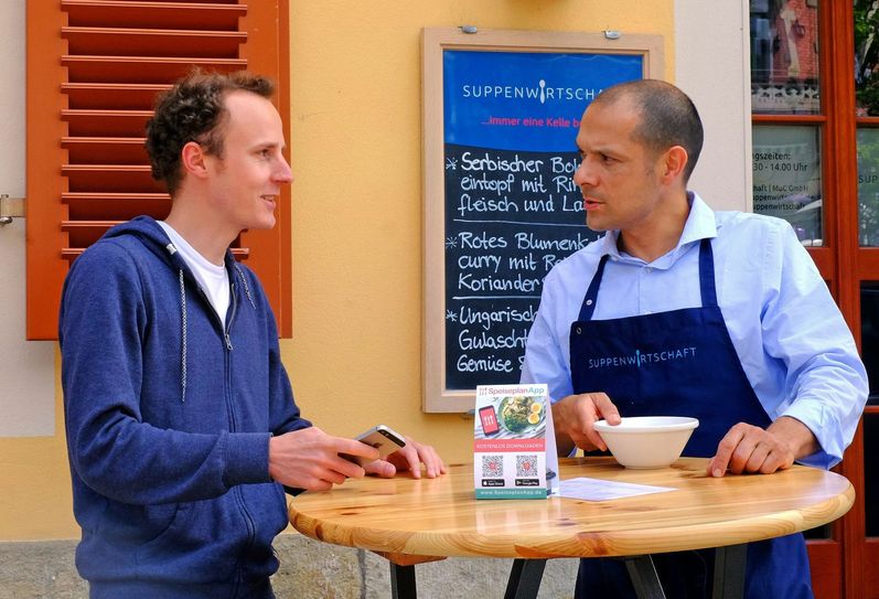 Martin Bruck im Gespräch mit Michael Malz (v.l.), Betreiber der Suppenwirtschaft am Schillerplatz. Foto: PR/SpeiseplanApp