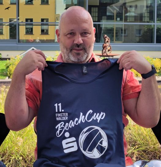 Lars Jäpel zeigt beim Pressegespräch das Shirt zum Beach-Cup 2023.  Foto: Weser