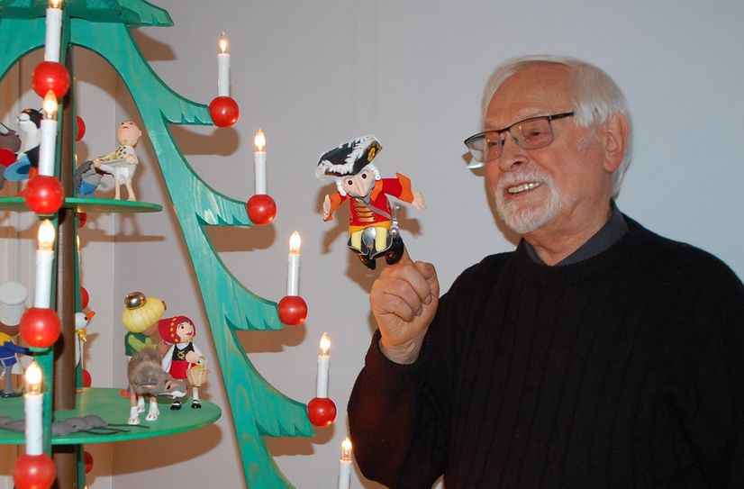Fredo Kunze zeigt auf seine Münchhausen-Figur, die an einer seiner Pyramiden schwebt.