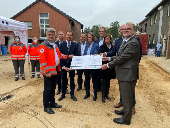 Ministerpräsident Kretschmer und Rüdiger Unger, stellvertretender Vorsitzender der Liga der Freien Wohlfahrtspflege in Sachsen, bei der symbolischen Spendenübergabe in Nordrhein-Westfalen. Foto: Sächsische Staatskanzlei