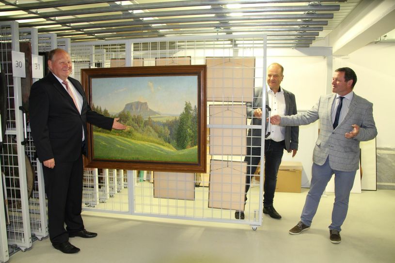 Klaus Brähmig (CDU), ehemaliger Bundestagsabgeordneter und Initiator der Schenkung, Prof. Dr. Thomas Gischke, Aufsichtsratsvorsitzender der Volksbank Pirna und Christian Schmidt-Doll von der Kultur- und Tourismusgesellschaft Pirna präsentieren das Ölgemälde im Depot des StadtMuseums.                        Foto: R. Rink