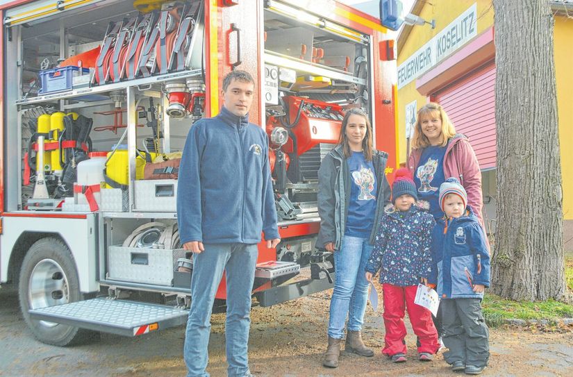 Peter Zschorn, Claudia Zschorn und Sahra Bischoff helfen Lindsey und Till (v.l.) beim Finden der Feuerwehrausrüstung am Einsatzfahrzeug.