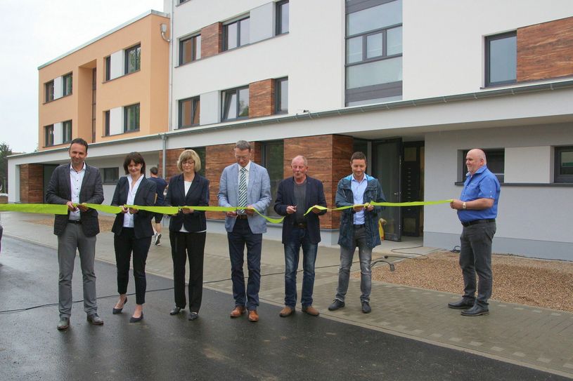 Oberbürgermeister Marco Müller (l.), Vorstandsvorsitzende  der Wohnungsgenossenschaft Kerstin Kluge, Vorstand der Wohnungswirtschaft Hagen Nickol sowie weitere am Bau Beteiligte geben den neuen Wohnblock zum Einzug frei. Foto: Farrar
