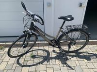 Ein schwarz-graues Trekkingrad der Marke Tourrex mit Gesundheitslenker.