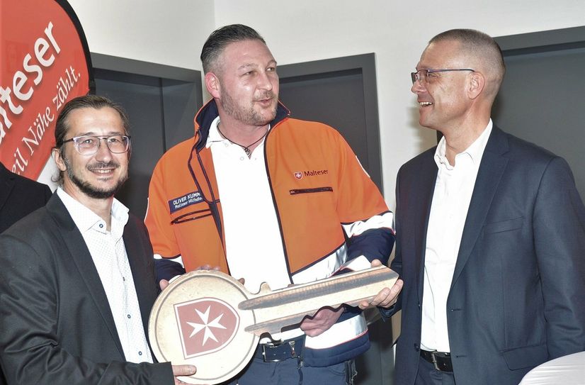 Malteser Oliver Kümmich, Leiter der Rettungswachen Großenhain und Thiendorf, und Bürgermeister Dirk Mocker erhalten vom Landrat Ralf Hänsel den symbolischen Schlüssel für die neue Rettungswache in Thiendorf.