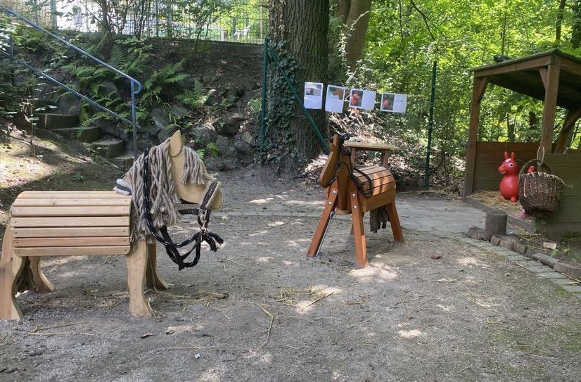 Der Stall für die Holzpferde im Garten der Kita.
