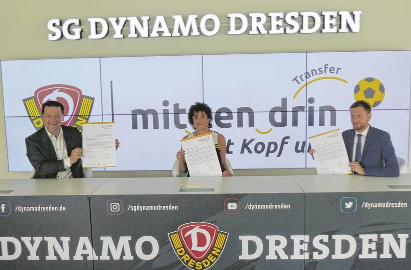 Dynamo-Dresden-Präsident Holger Scholze (li.), Anja Jäpel-Nestler (stellv. Direktorin Volkshochschule Dresden) und Ministerpräsident Michael Kretschmer beim Unterzeichnen der Schirmherrschaftsurkunden.