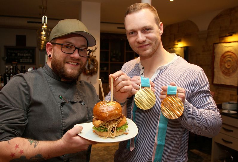 Küchenchef Magnus Garbotz vom "Platzhirsch" präsentiert zusammen mit Francesco Friedrich den "Goldburger". Foto: D. Förster