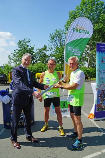 Freitals Oberbürgermeister Uwe Rumberg, Läufer Uwe Angerer und Läufer Wolfgang Finke (v.l.n.r.) bei der Übergabe des Staffelstabes »Tag der Sachsen«. Foto: Stadt Freital