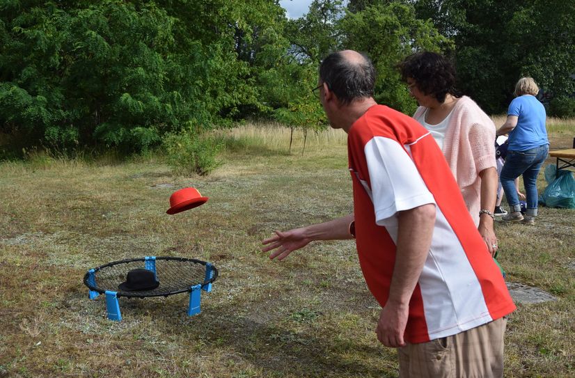 Ein Teilnehmer beteiligt sich am Zielwerfen mit Faschingshüten.