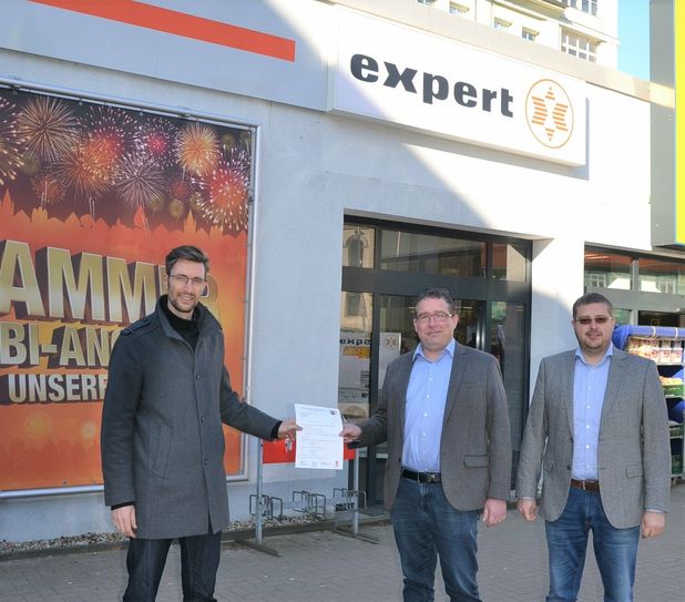 Amtsverweser Ronald Kretzschmar (li.) übergibt den Förderbescheid für den Umbau an die »expert«-Geschäftsführer Lars Schwarck und Konrad Formella.