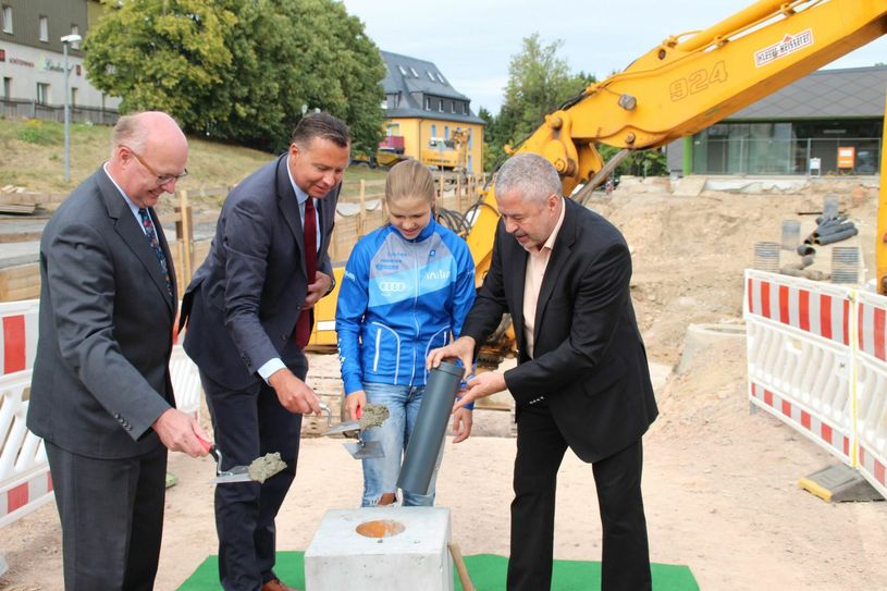 Landrat Michael Geisler (re.) versenkt die Zeitkapsel . Staatssekretär (SMI) Prof. Dr. Günther Schneider (l.), Staatssekretär (BMI) Stephan Mayer und eine Sportschülerin helfen.  Foto: asc