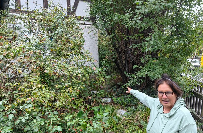 Monika Hölzel zeigt, bis wohin ihr Grundstück abgetragen werden soll.