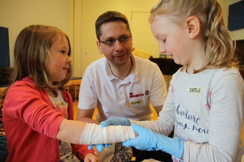 Unter den Augen des Erste-Hilfe-Ausbilders René Rüggebrecht bekommt Julie (links) einen Verband von Tara angelegt. Foto: Schramm