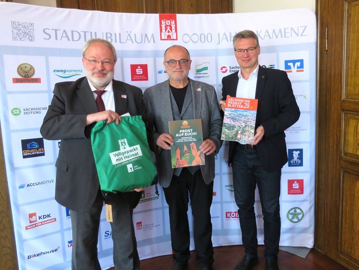 Wulf-Dietrich Schomber, Oberbürgermeister Roland Dantz und Dr. Lars Dannenberg (v.l.n.r.) präsentieren das Fan-Paket für Mieter sowie die Sonderausgabe der Sächsischen Heimatblätter zum Stadtjubiläum Kamenz.