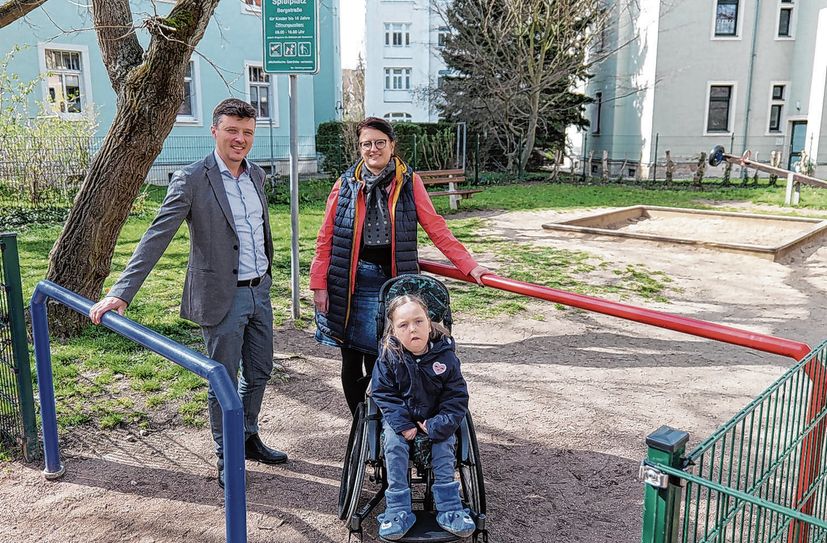 Bürgermeister Markus Renner (l.) und Kitaleiterin Carina Richter sind froh: Dank des erfolgreichen Projekts aus dem Bürgerhaushalt 2023 kann Ida (r.) nun den Spielplatz an der Bergstraße barrierefrei erreichen.