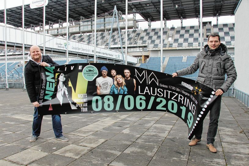 Holen Pop-Ikone Nena nach Klettwitz auf dem Lausitzring: Thomas Alisch (li.) und Alexander Reinig (re.) stehen mit einem der zahlreichen Banner vor der Tribüne des jetzigen Dekra-Testovals. Foto: sts