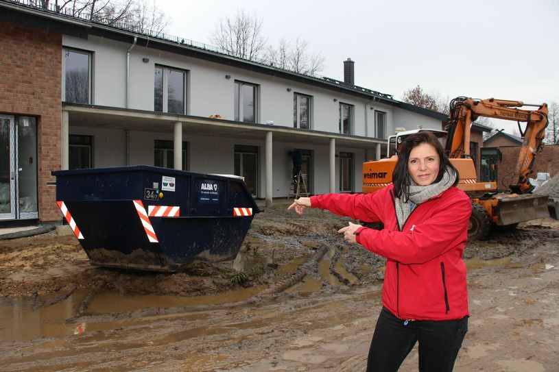 Schaukel statt Schuttmulde: Daniela Konzack, Pflegedienstleiterin Hospiz, zeigt es an. An der Stelle, wo jetzt die Absetzmulde steht, soll künftig eine Schaukelkombination für Freude sorgen. Foto: sts