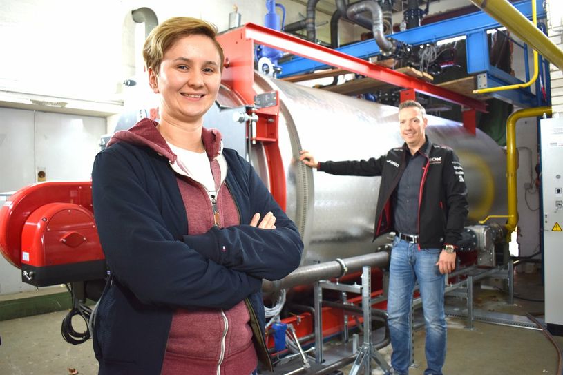 Julia Kurze von der Wohnungsbaugesellschaft und Bürgermeister Michael Herfort stehen vor dem neuen Brennwertkessel im Wilthener Heizhaus.