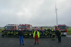 Gemeinsam haben Sie die Übung im Windpark Kittlitz II organisiert: Markus Romberg, technischer Geschäftsführer Repartner Wind GmbH (l.), Thomas Brossok, EMIS Windservice (Mitte) und Hartmut Wassermann, Stadtbrandmeister Lübbenau (r.), vor einem Teil der an der Ausbildung beteiligten Wehren bzw. deren Mitglieder. Foto: EMIS