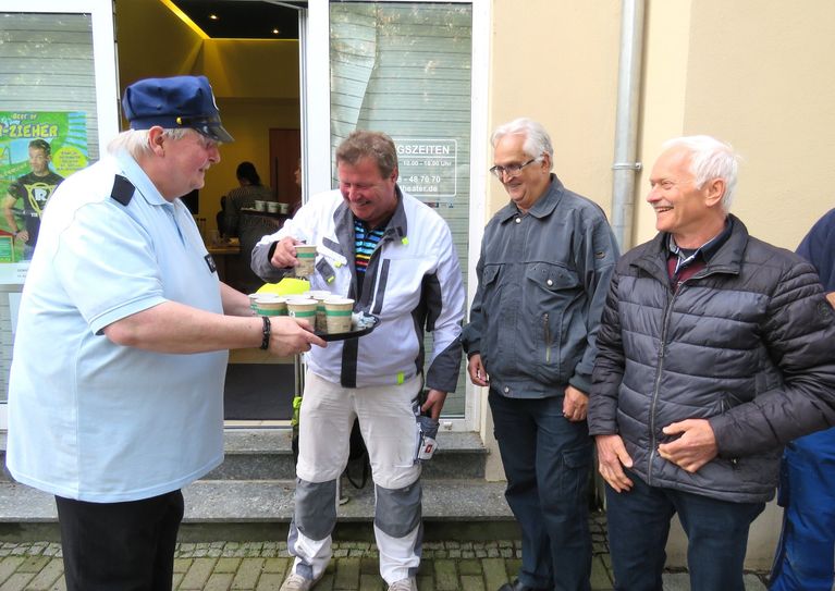 Schauspieler Hans-Jörg Hombsch alias Polizist Holm serviert eigenhändig Kaffee für die drei am längsten Wartenden unter den Kartenkäufern René Zeis, Ulrich Prietzel und Friedrich Reppe (v.l.n.r.). Foto: Matthias Stark