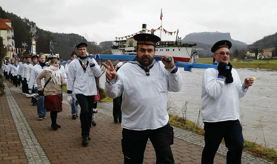 Die Matrosen tragen die Schiffsmodelle.