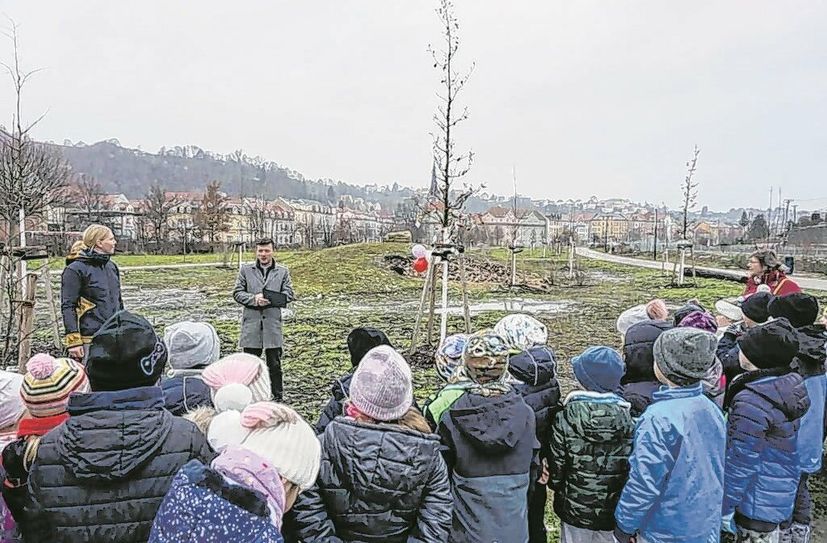 Bürgermeister Markus Renner übergibt im Bürgergarten im Beisein der 1. Klassen der Questenberg-Grundschule die Urkunde an den Förderverein der Schule.