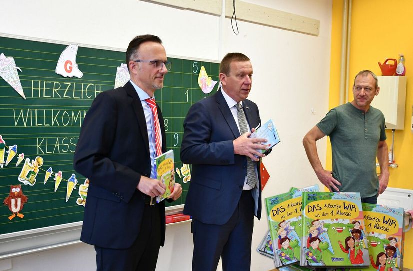 Sparkassen-Vorstandsmitglied Thomas Jentzsch (li.), Landrat Christian Jaschinski (Mitte) und Schulleiter Jochen Haase (re.) überreichten den Schulanfängern die Bücher.