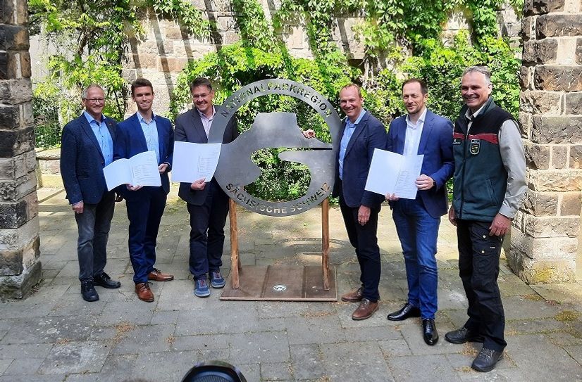 Staatsminister Wolfram Günther (3. v. re.) überreicht die Förderbescheide an (v.l.n.r.) Ekkehard Schneider (stellv. Oberbürgermeister Sebnitz), Kevin Henker (Hauptamtsleiter Sebnitz), Daniel Brade (Bürgermeister Hohnstein), Thomas Kunack (Bürgermeister Bad Schandau) und Uwe Borrmeister (Leiter Nationalparkverwaltung Sächsische Schweiz).