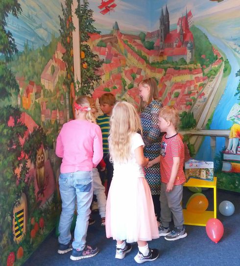 Kinder entdecken Meißner Motive und Momente auf dem Wimmel-Wandgemälde in der Stadtbibliothek. Foto: Stadt Meißen