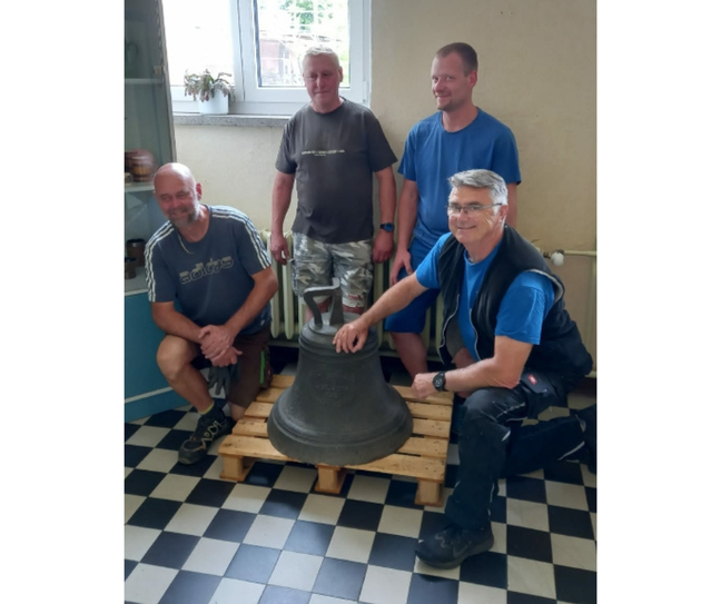 Andreas Arras (Vorsitzender der TSG Rot-Weiß Kostebrau e.V.), Gerd Paulo (Ortswehrführer der FFW Kostebrau), Robert Lerche-Gaumer (Jugendwart der FFW Kostebrau) und  Lutz Kunze (1. Vorsitzender des Fördervereins »Lebenswertes Kostebrau« e.V.) beim Transport der Glocke in die alte Schule.