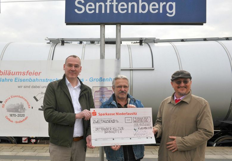 Andreas Fredrich (l.), Bürgermeister der Stadt Senftenberg und Roland Osiander (r.), Geschäftsführer der KWG-Senftenberg, übergeben einen Scheck in Höhe von 2000 Euro an Frank Weser (Mitte), Organisator der 150-Jahr-Feier der Eisenbahnstrecke Großenhain-Cottbus. Foto: Peter Aswendt