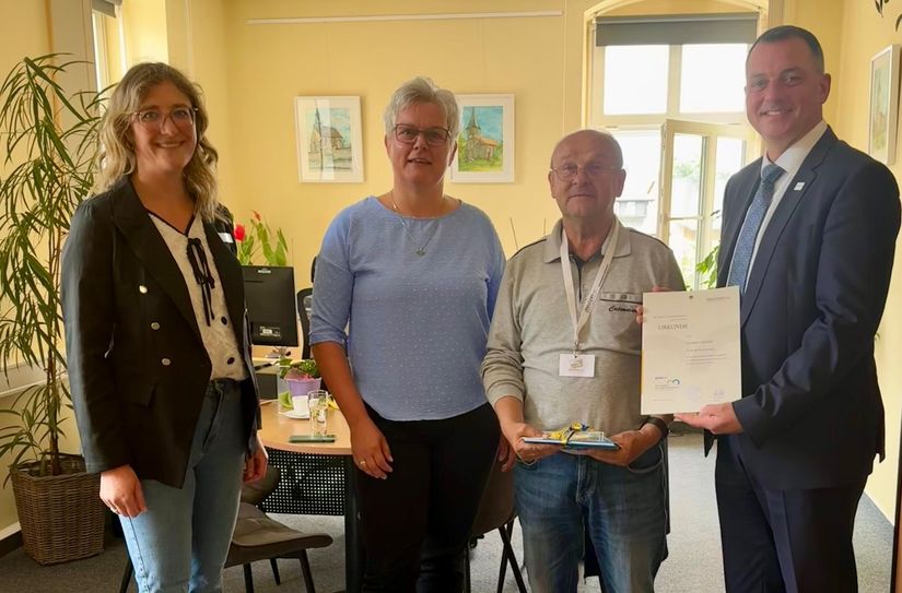 Die Ehrenamtsbeauftragte Dunja Reichelt, Bürgermeisterin Madeleine Rentsch und Landrat Udo Witschas überreichen Günther Schuster die besondere Auszeichnung für sein ehrenamtliches Engagement.