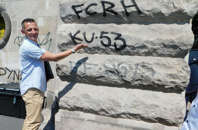Jens Ehlemann, Servicebereichsleiter der DB, zeigt wie ein Schriftzug nach und nach durch das Abstrahlen verblasst.