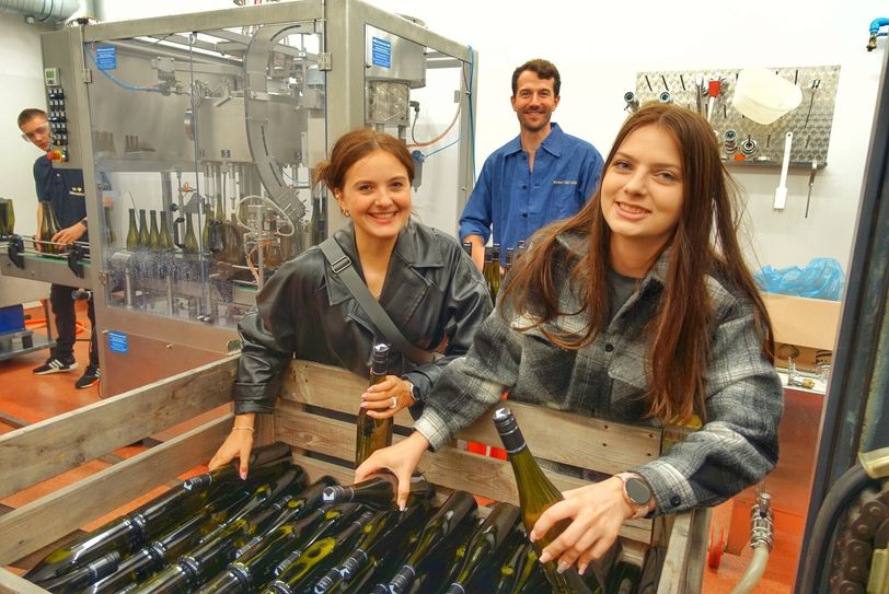 Chantal und Chantal bei der Abfüllung des Azubi-Weins. Kellermeister Jacob Wiedemann überwacht die ganze Prozedur. Foto: Schramm