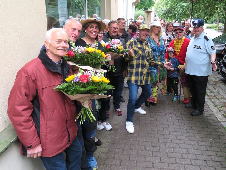 Die Schauspieler des Radeberger Biertheaters mischten sich unter die Wartendenden beim Kartenvorverkauf. Jene, die schon ganz zeitig da waren, erhielten einen Blumenstrauß aus den Hand des künstlerischen Leiters, Thomas Böttcher (m.).