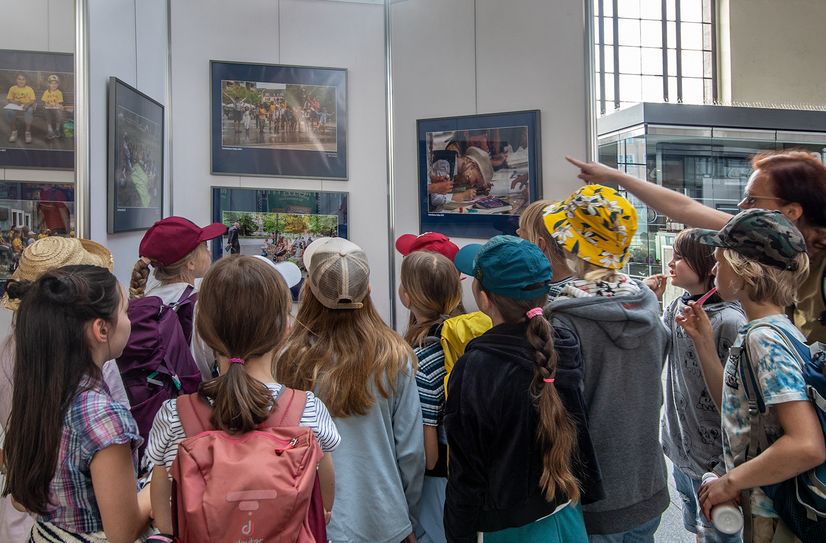 Eine Schulklasse betrachtet im Dresdner Hauptbahnhof die Ausstellung mit Bildern der Erich Kästner Rallye 2022.